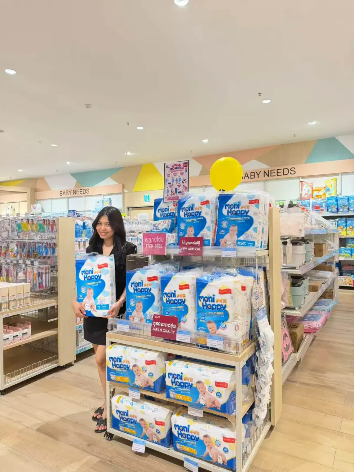 Moni Happy endcap display at AEON Cambodia with NEW ARRIVAL and JAPAN QUALITY signage, full range of diaper sizes on display