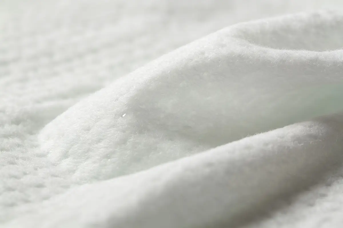Organic baby wipes products with natural ingredients: aloe vera leaves, chamomile flowers, water drops, soft green packaging, clean white background
