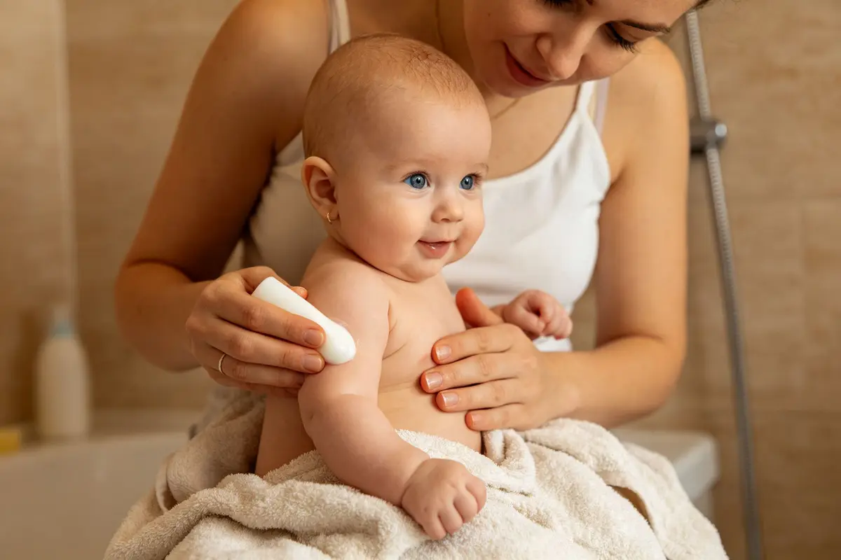 Mother applying gentle lotion to baby's skin after bath